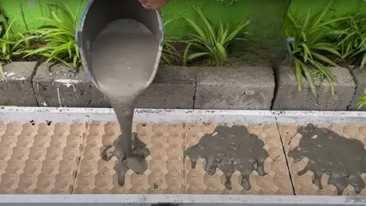 Mischen Sie feuchten Zement und leere Kartons, um einen einzigartigen Blumentopf für Ihren Garten herzustellen.